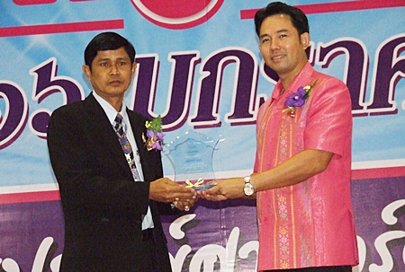Kasem Chiewjew (left), principal of Pattaya School No. 9, receives an award for outstanding principal of the year from Mayor Itthiphol Kunplome.